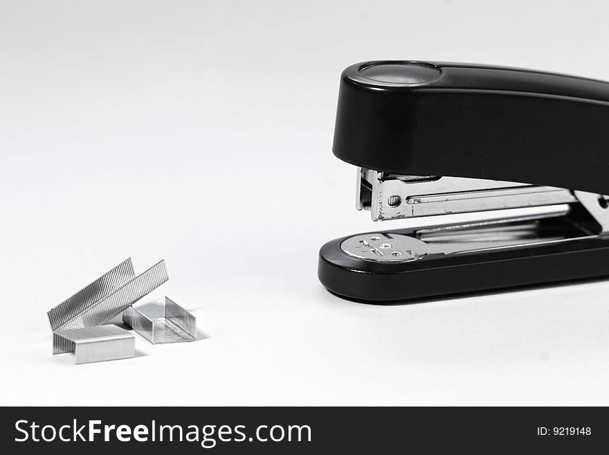 Black stapler and staples isolated on white background