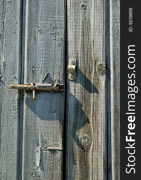 Old rusty handle on the wooden door