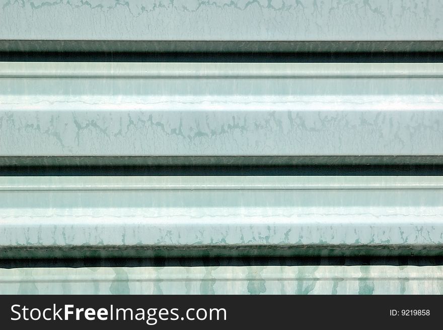 A rusty corrugated iron metal fence close up