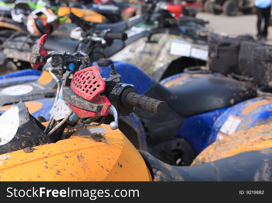 Detail of an ATV brake in a crowd of bikes during a muddy race pause. Detail of an ATV brake in a crowd of bikes during a muddy race pause.