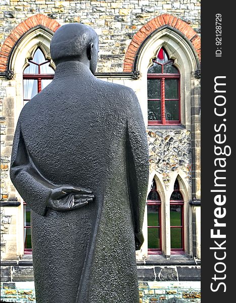 When it comes to sculptures, I am intrigues by details. Was the detail deliberate and part of a message or just a detail that was needed to make the piece complete? Here on the lawn just north of the East Block on Parliament Hill in Ottawa, Ontario, the sculpture of William Lyon Mackenzie King stands looking towards one of the parliament buildings. The sculpture is in a more modern style compared to the many other bronze statues of former prime ministers and other political figures that dot the ground of the parliament. The left hand of Mackenzie King is the detail that interests me the most. Was this a typical posture for the former prime minister? Or is this some commentary on either him or politicians in general? When I was in grade school, it was common for the students to make false promises with one hand behind one&#x27;s back and fingers crossed. While perhaps an appropriate gesture for a politician, is it perhaps is a commentary on King&#x27;s honesty? I prefer to not research the intentions of the artist and let the uncertainly remain. Discovering the true meaning &#x28;or lack of meaning&#x29; in the hand position would result in a reduced interest in the sculpture. Here&#x27;s to Mackenzie King and all others who gazed off into the distance with one hand behind their backs. When it comes to sculptures, I am intrigues by details. Was the detail deliberate and part of a message or just a detail that was needed to make the piece complete? Here on the lawn just north of the East Block on Parliament Hill in Ottawa, Ontario, the sculpture of William Lyon Mackenzie King stands looking towards one of the parliament buildings. The sculpture is in a more modern style compared to the many other bronze statues of former prime ministers and other political figures that dot the ground of the parliament. The left hand of Mackenzie King is the detail that interests me the most. Was this a typical posture for the former prime minister? Or is this some commentary on either him or politicians in general? When I was in grade school, it was common for the students to make false promises with one hand behind one&#x27;s back and fingers crossed. While perhaps an appropriate gesture for a politician, is it perhaps is a commentary on King&#x27;s honesty? I prefer to not research the intentions of the artist and let the uncertainly remain. Discovering the true meaning &#x28;or lack of meaning&#x29; in the hand position would result in a reduced interest in the sculpture. Here&#x27;s to Mackenzie King and all others who gazed off into the distance with one hand behind their backs.