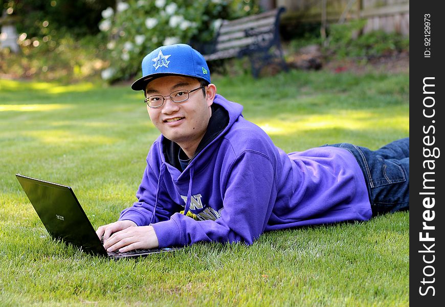 A person on the grass with his laptop out. A person on the grass with his laptop out.