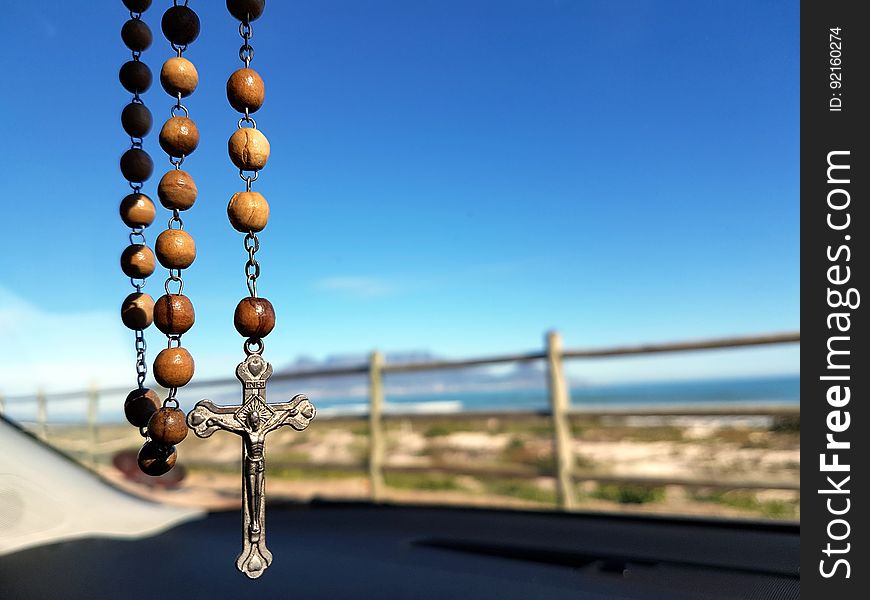 Selective Focus Photo of Brown and Silver Rosary