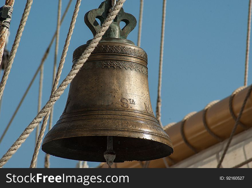 An old ship's bell hanging from the yardarm. An old ship's bell hanging from the yardarm.