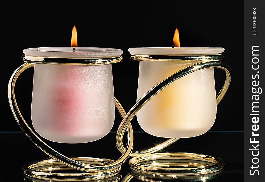 A pair of candles in joined candle holders.
