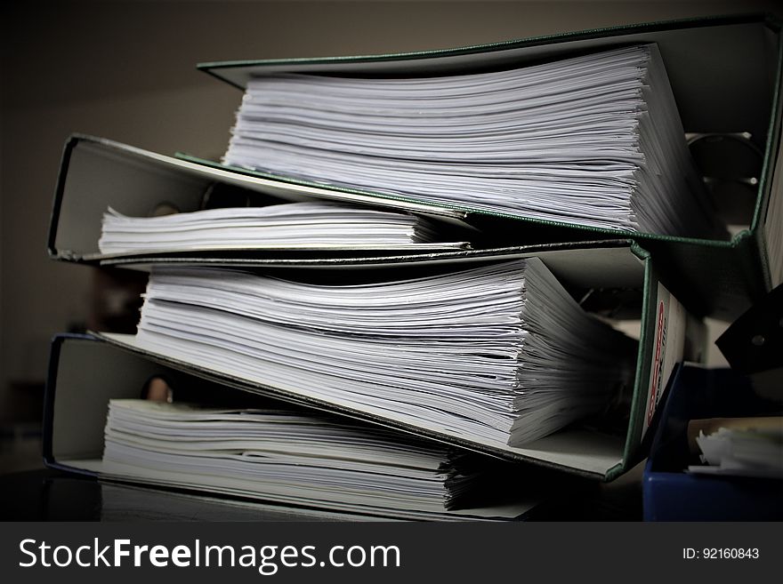 A stack of folders full of papers.