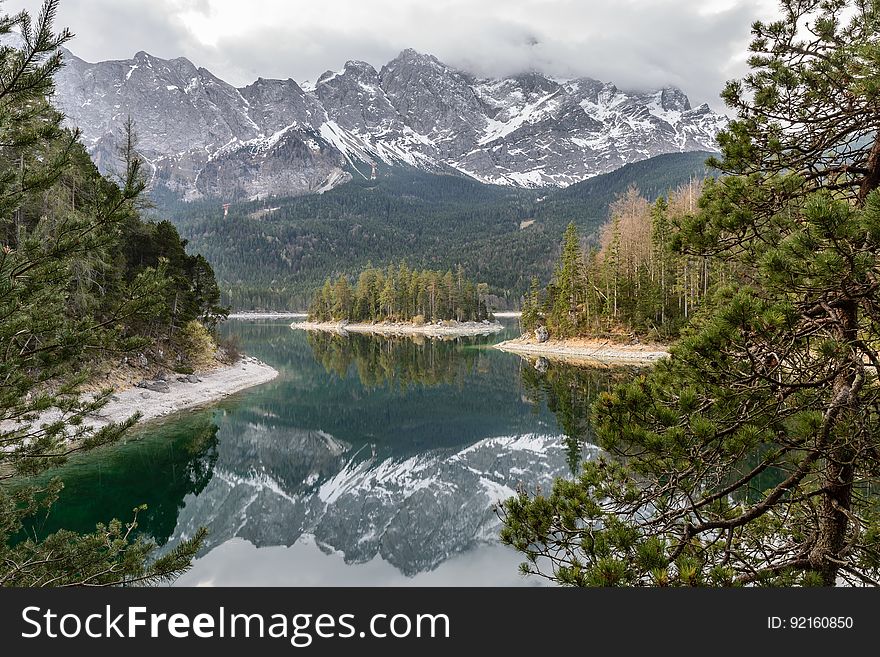 A river passing through an autumn forest with snowy mountains in the distance. A river passing through an autumn forest with snowy mountains in the distance.