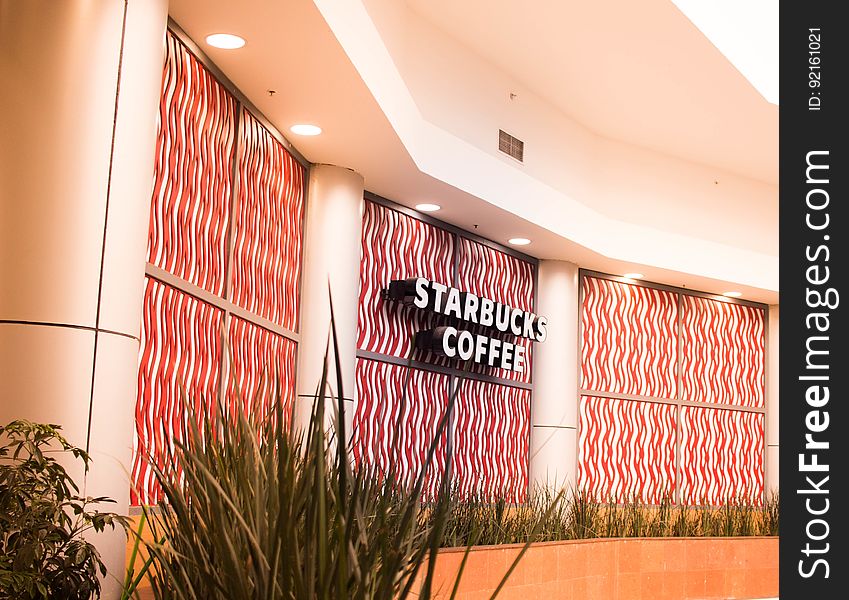 Signage for Starbucks Coffee on colorful interior wall. Signage for Starbucks Coffee on colorful interior wall.