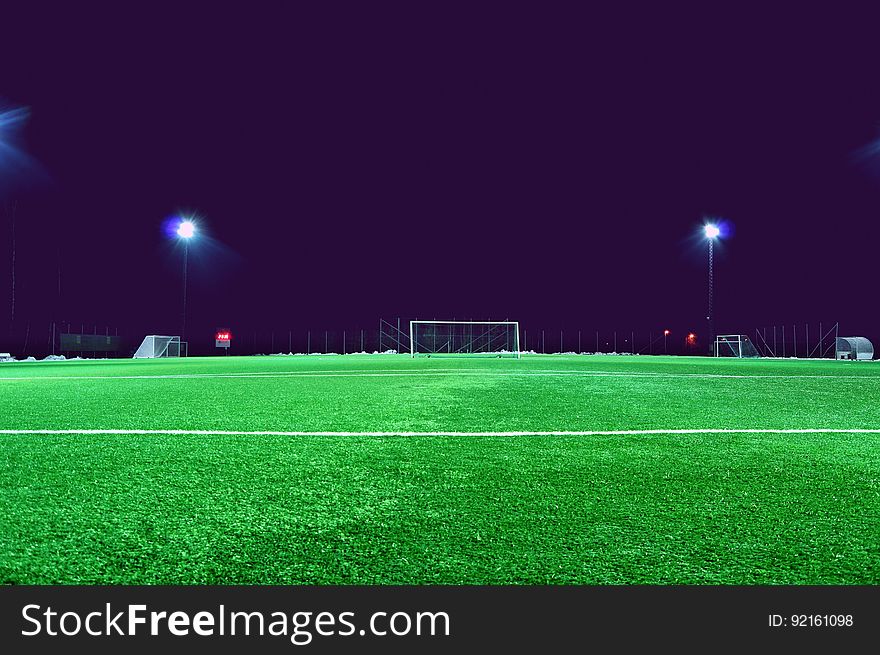 An empty soccer field at night time.