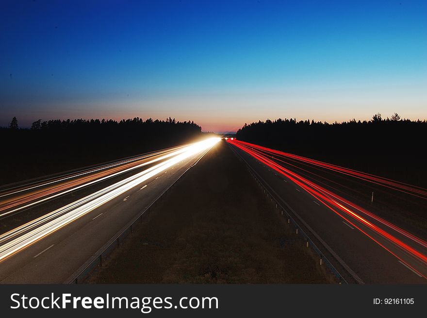 A long exposure of a highway at night with the light trails of the passing traffic. A long exposure of a highway at night with the light trails of the passing traffic.