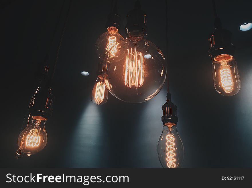 A bunch of incandescent light bulbs hanging from the ceiling. A bunch of incandescent light bulbs hanging from the ceiling.