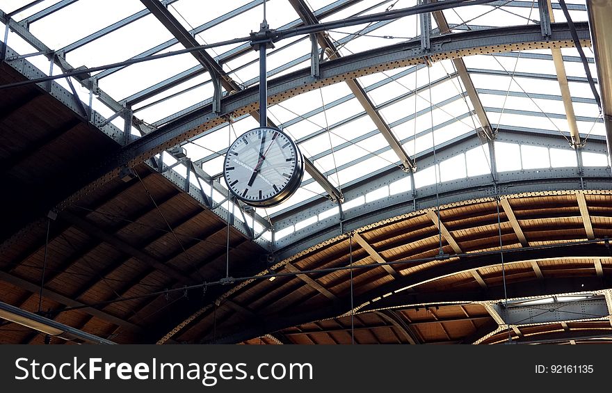 A clock hanging from the ceiling of a transit terminal. A clock hanging from the ceiling of a transit terminal.