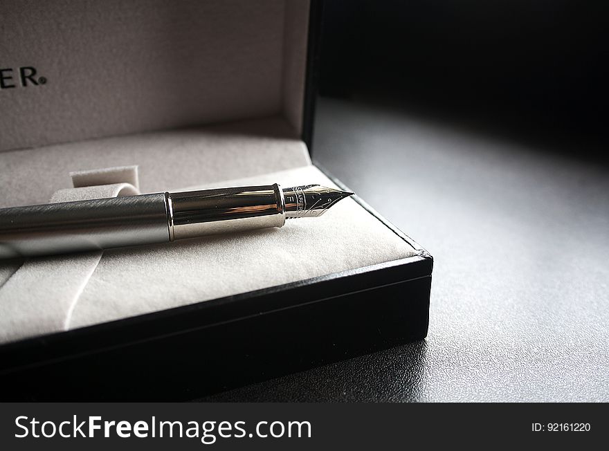 Close up of metal fountain pen in box.