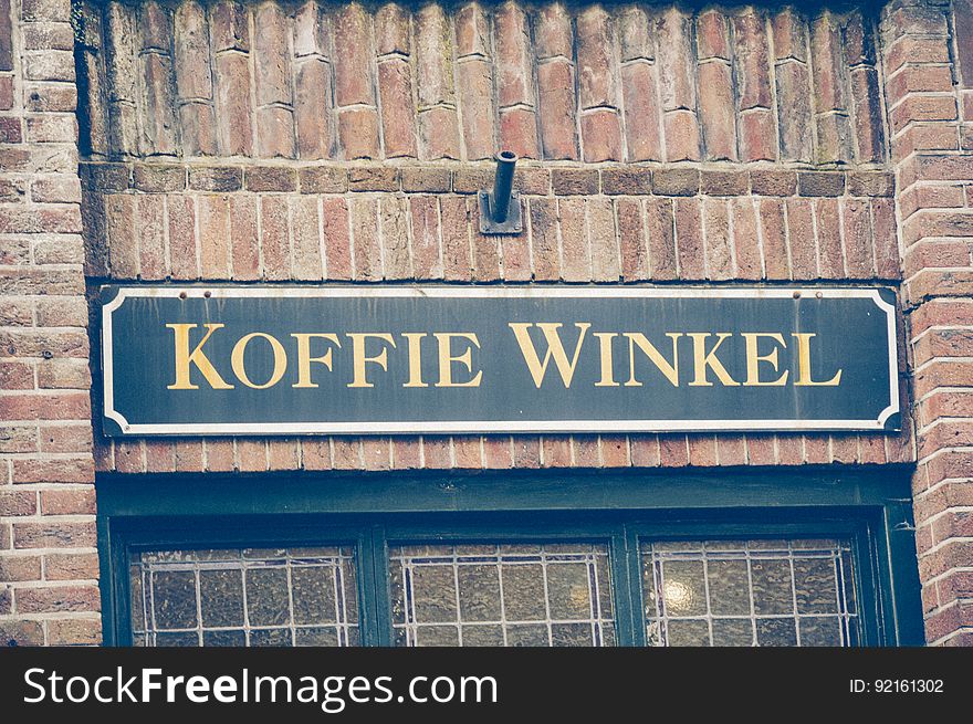 Sign with Koffie Winkel on exterior of brick building. Sign with Koffie Winkel on exterior of brick building.