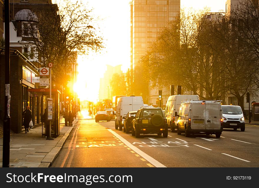 Black And White Vehicles Traveling On Gray Asphalt Road During Sunset