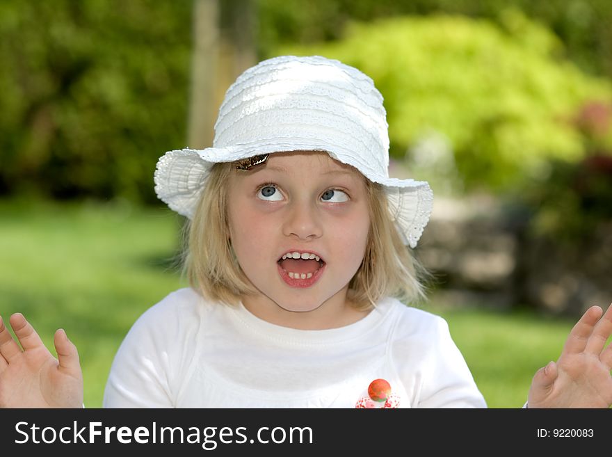 Young girl is frightened, because of a chafer beetle ceawling on her hat