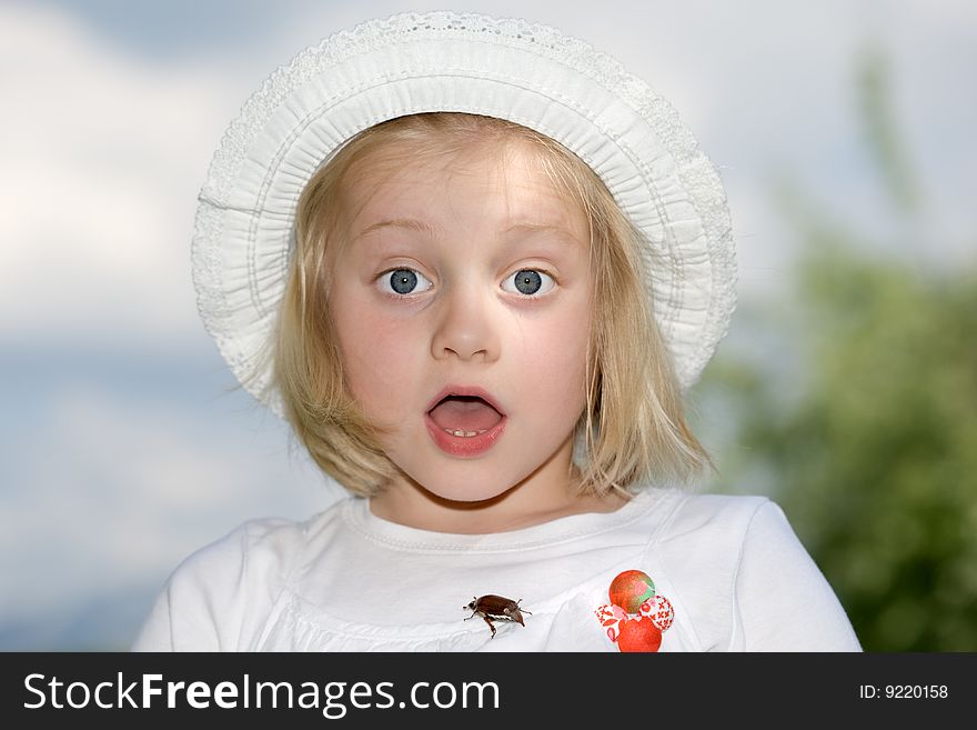 Young girl is frightened, because of a chafer beetle