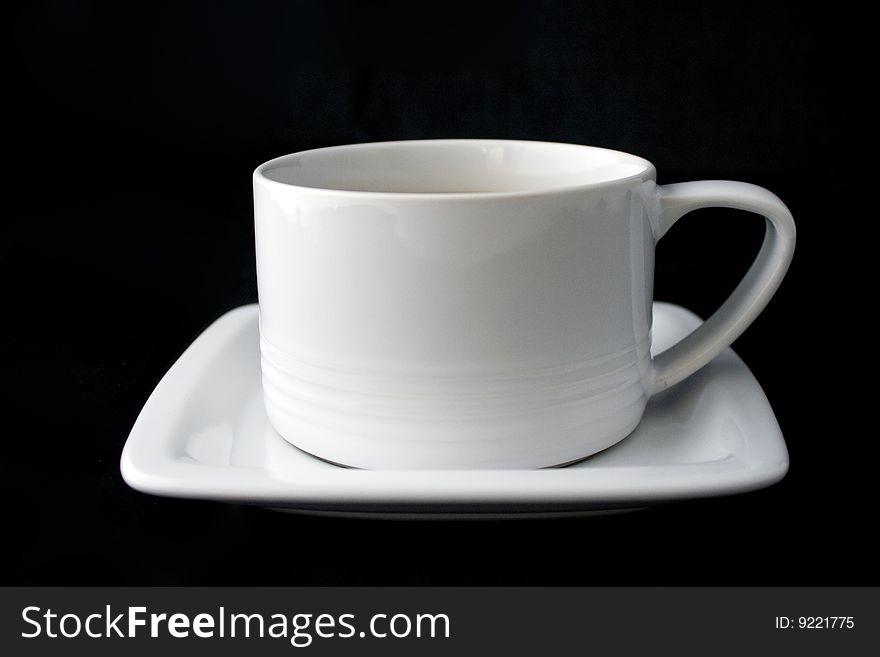 White coffe cup and plate on black background.