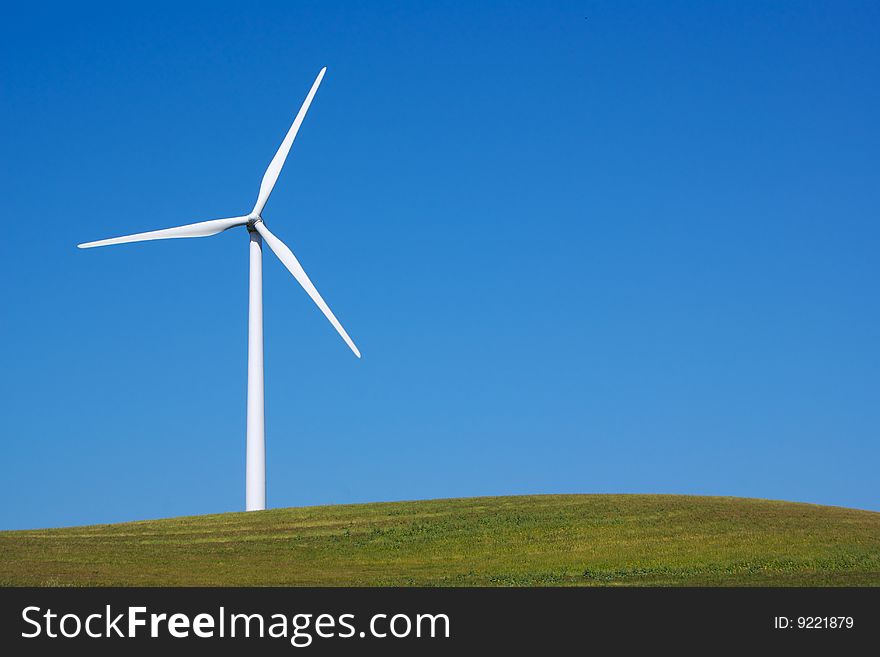 Windmill with fresh green grass and clear blue sky in summer. Windmill with fresh green grass and clear blue sky in summer