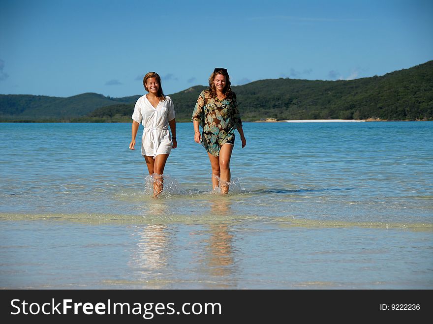 Two attractive young women walking out of the water to the beach. Two attractive young women walking out of the water to the beach