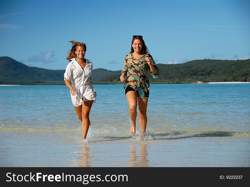 Two Young Women Runing Out Of The Water