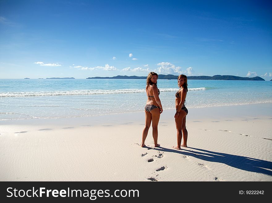 Two Young Girls Standing By Paradise Ocean