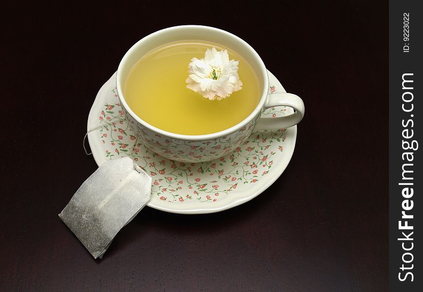 Floral tea on a dark brown table with flowers. Floral tea on a dark brown table with flowers
