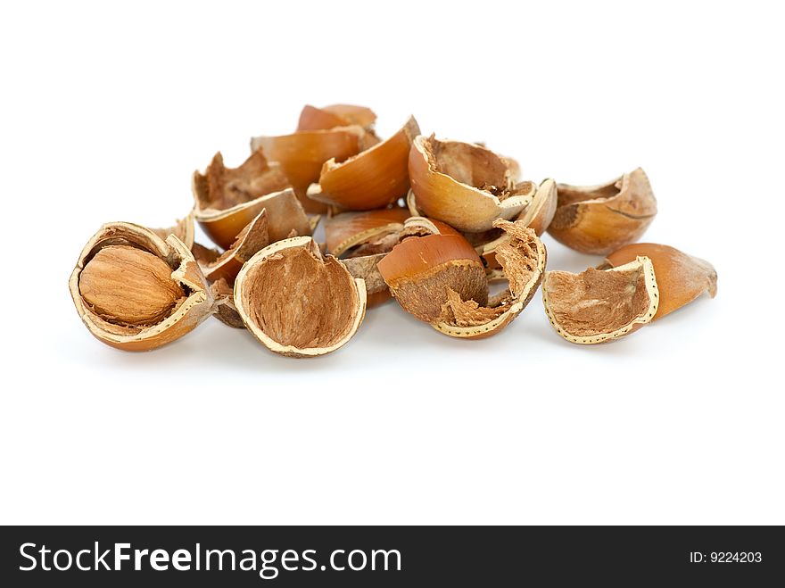 Small pile of hazelnuts shells and one cracked isolated on the white background