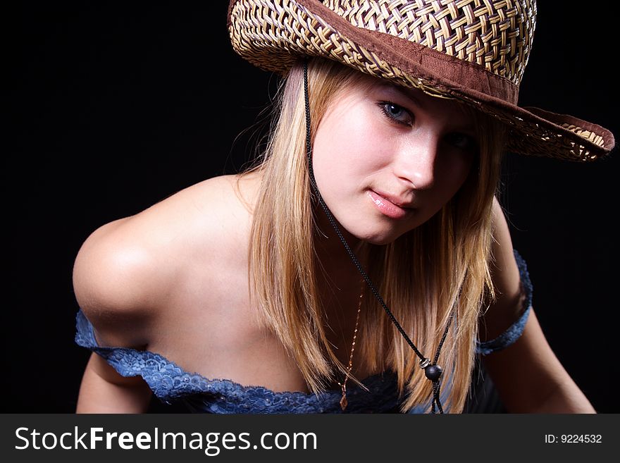 Nice girl in a hat on a black background
