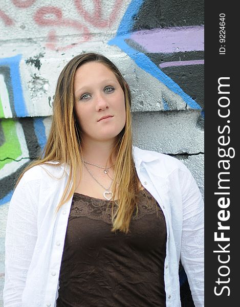 A young woman standing next to a graffiti wall. A young woman standing next to a graffiti wall