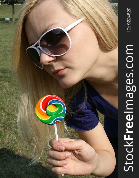 Girl with lollipop standing in a park