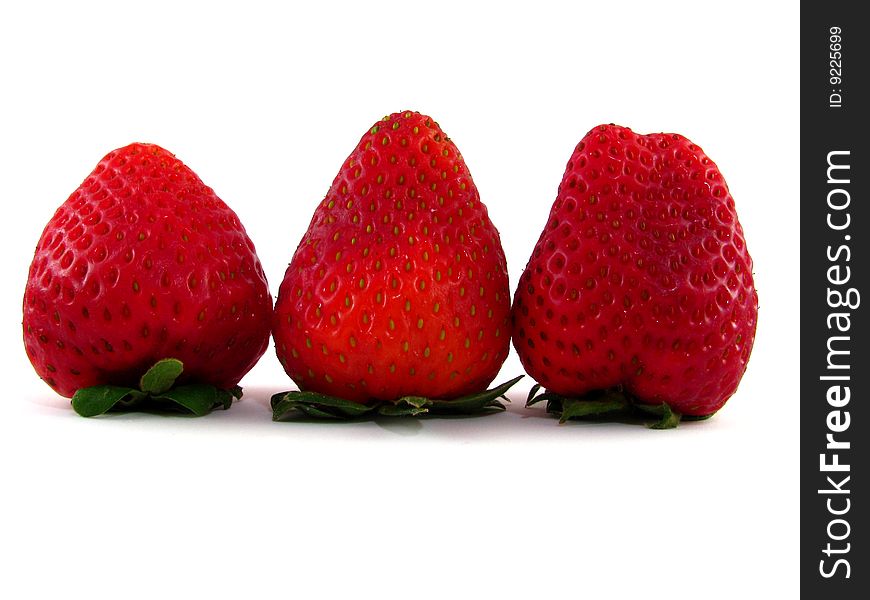 A row of three strawberries on a white background
