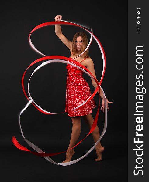 Elegant young flexible woman in red-white outfit with two ribbons. Elegant young flexible woman in red-white outfit with two ribbons