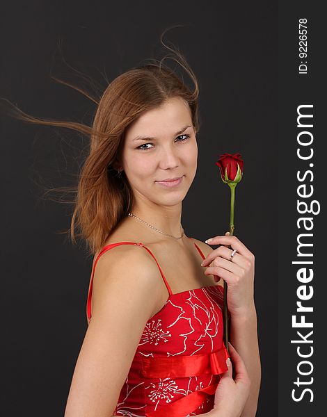 Portrait of young woman in red-white outfit with red rose. Portrait of young woman in red-white outfit with red rose