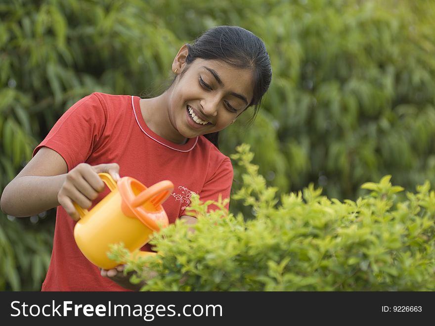 Portrait of beautiful girl watering plants