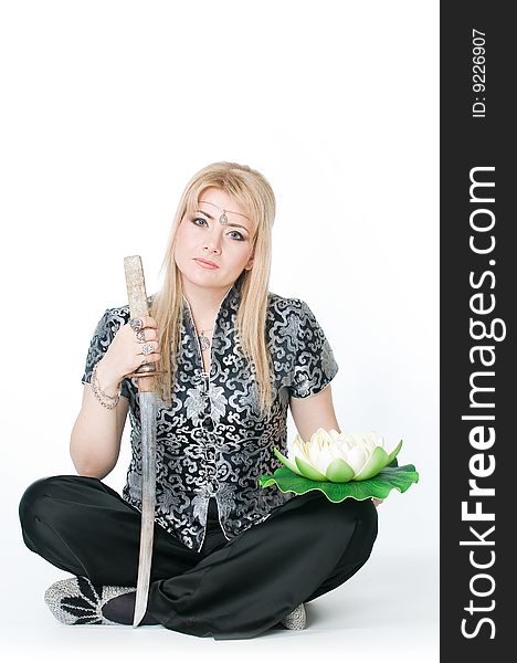 Woman sitting in lotus pose with katana, isolated on white background