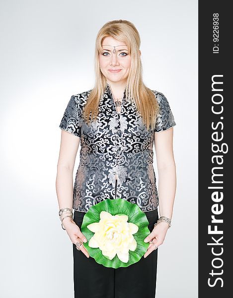 Attractive woman with lotus flower, studio shot