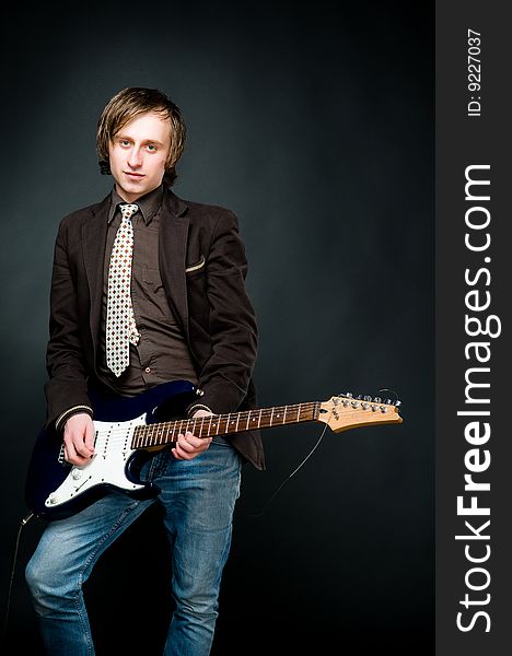 Young man playing electro guitar, studio shot