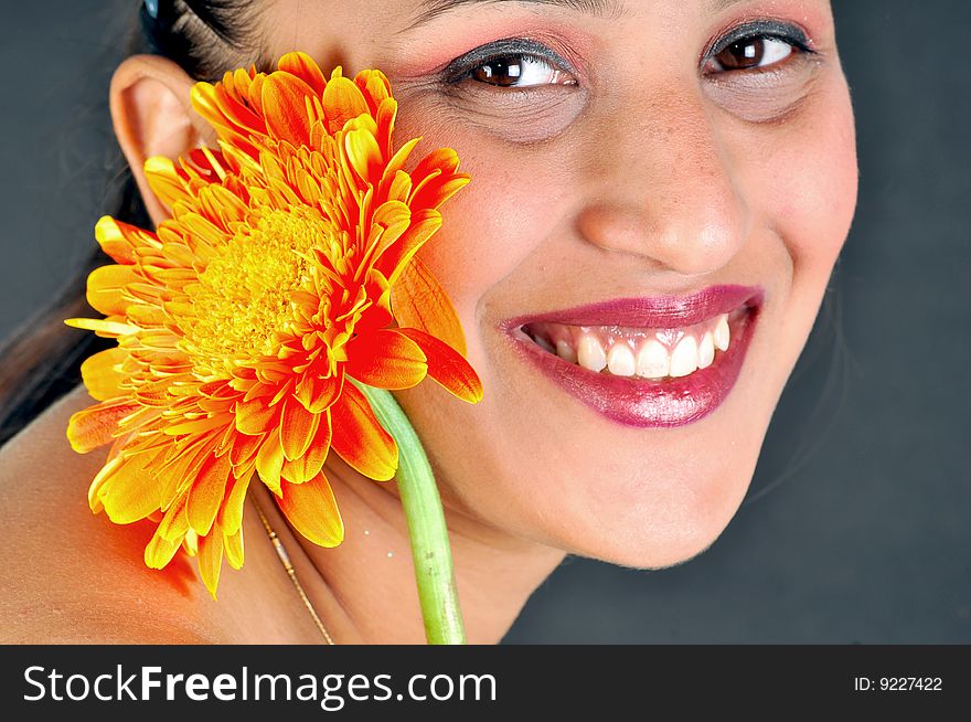 Smiling girl with flower in studio. Smiling girl with flower in studio.