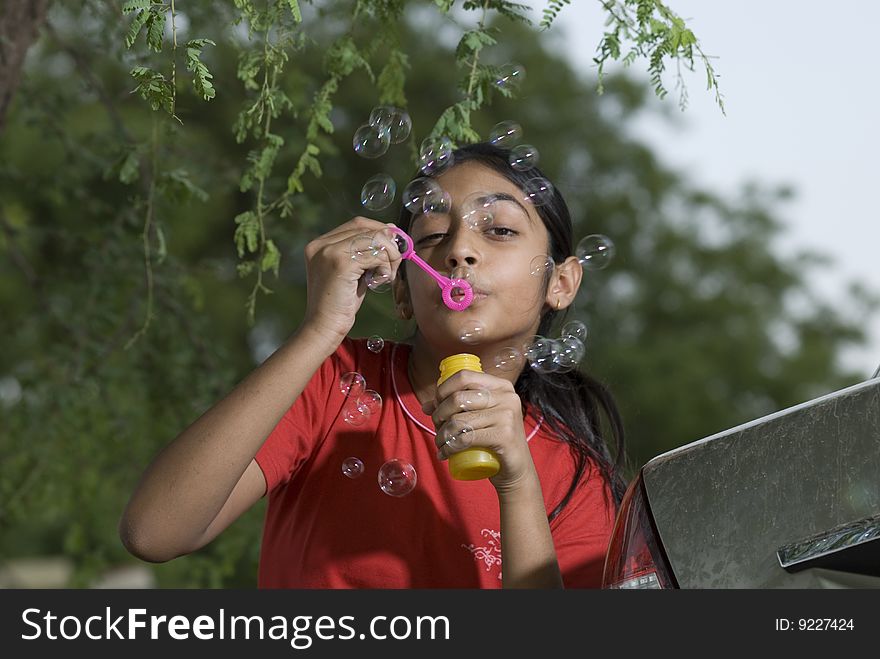 Portrait of beautiful girl blowing bubble