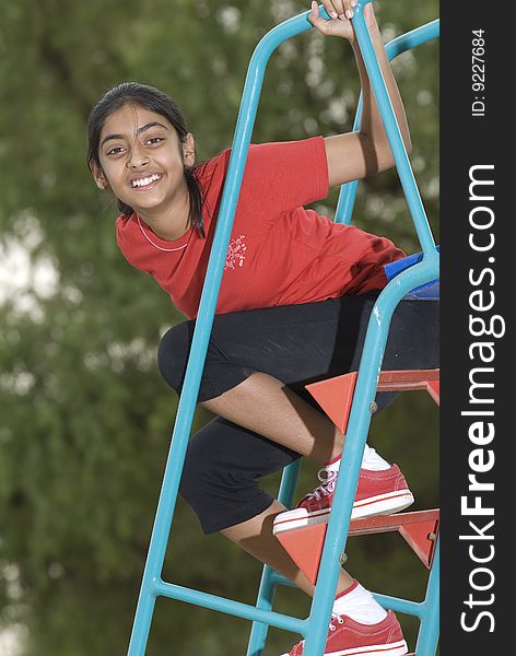 Portrait of beautiful girl climbing on slide stairs