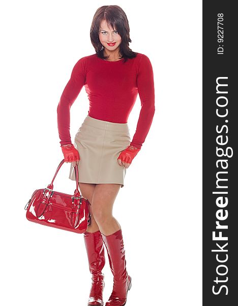 Young woman poses in a short leather skirt and red lacquer boots. Young woman poses in a short leather skirt and red lacquer boots
