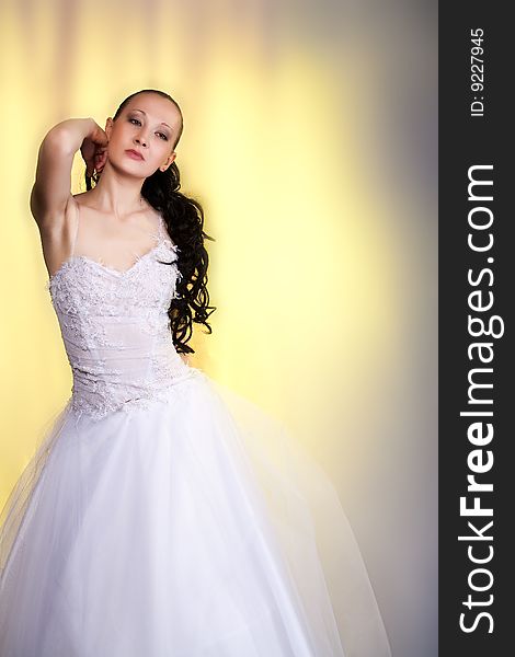 Girl in white wedding dress standing with hands lifted up