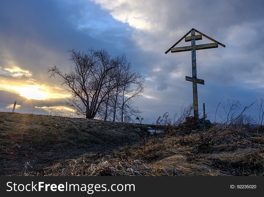 A Wooden Cross At Sunset