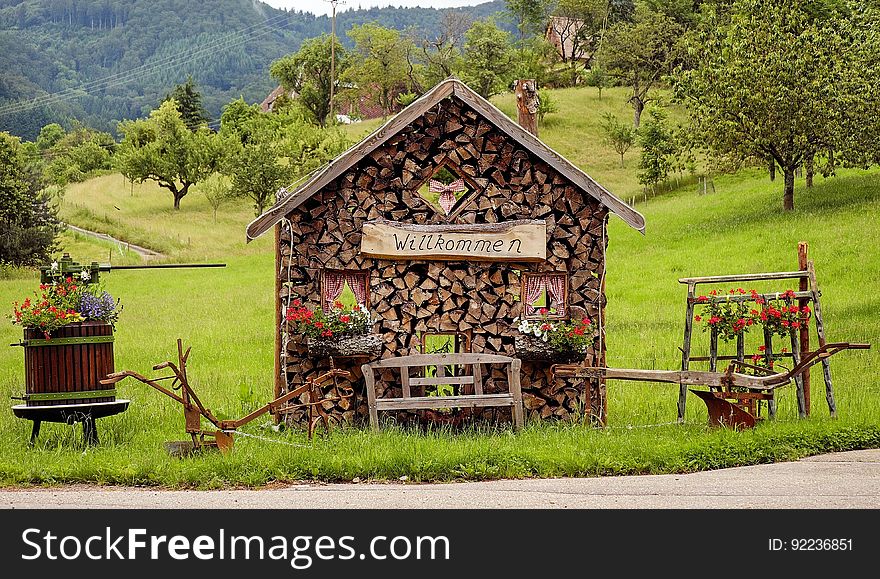 Rustic woodshed in countryside with welcome sign on sunny day. Rustic woodshed in countryside with welcome sign on sunny day.