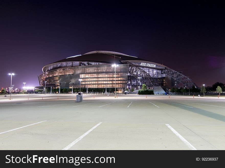 Exterior of AT&T Arena, home of Dallas Cowboys, illuminated at night with empty parking lot. Exterior of AT&T Arena, home of Dallas Cowboys, illuminated at night with empty parking lot.