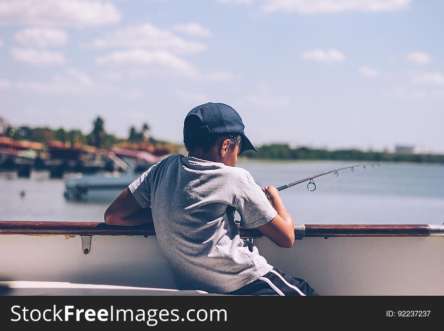 A boy fishes on a dock. A boy fishes on a dock.