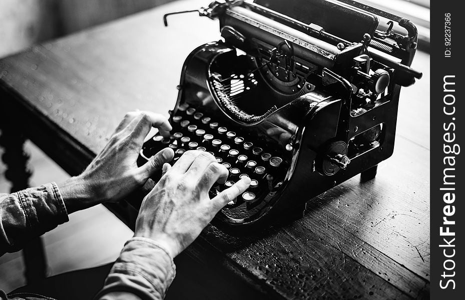 The hands of an elderly person typing on an old fashioned typewriter which used ribbon (here paper is absent from the carriage). The hands of an elderly person typing on an old fashioned typewriter which used ribbon (here paper is absent from the carriage).