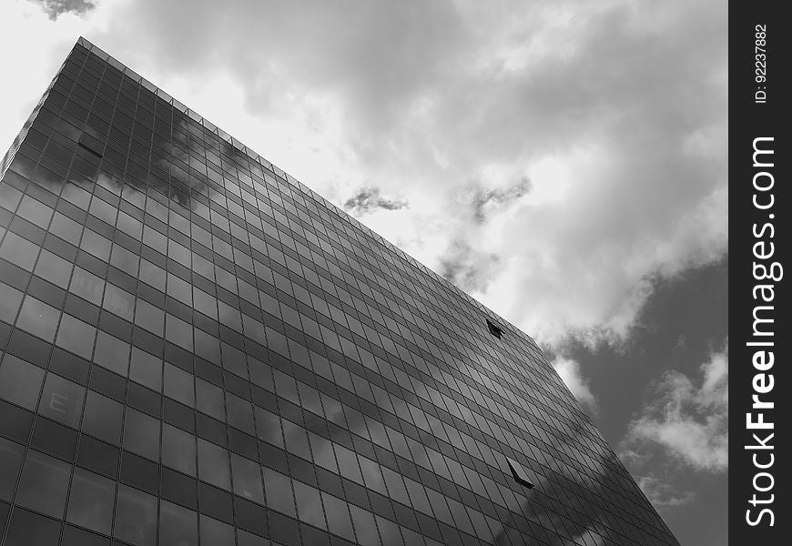 Skyscraper facade on a gray day with low dark clouds. Skyscraper facade on a gray day with low dark clouds.