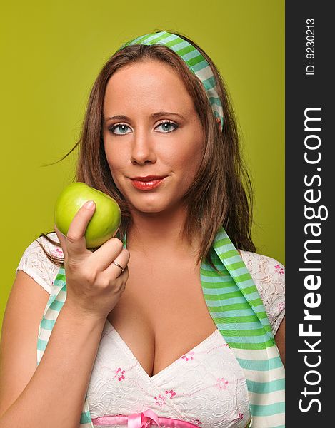 Young woman holding a green apple against a green background. Young woman holding a green apple against a green background
